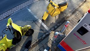 Elektrischer Vespa Roller von prosimo an öffentlicher Ladesäule – Laden unterwegs